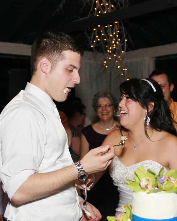 a man and woman smile as they prepare to cut their wedding cake