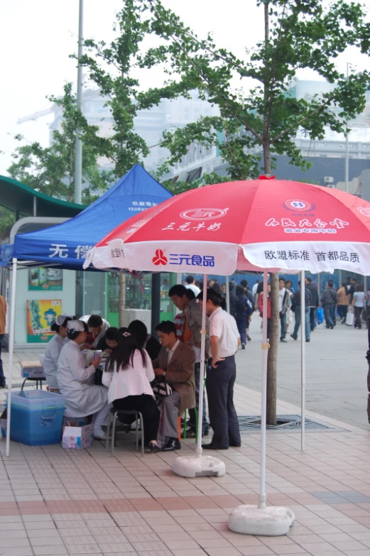 there are people standing under an umbrella on the street