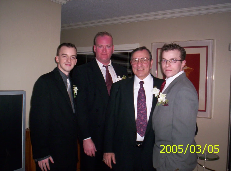 four people wearing suits pose for a picture