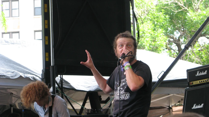 a man standing on a stage holding a microphone