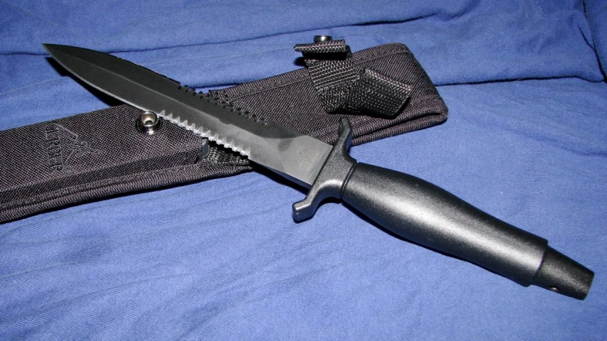 a long knife laying on a blue sheet