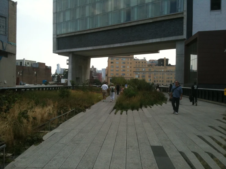 there are people walking down a wooden walkway