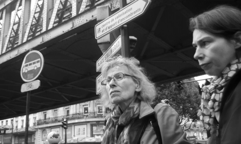 black and white pograph of woman in front of street signs