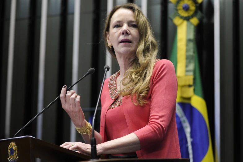 a woman stands at a podium while speaking