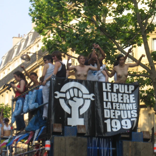 several people standing in the back of a truck with the sign