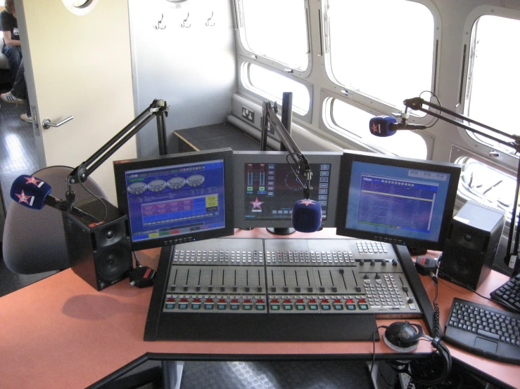 an audio mixing machine with three monitors and microphone