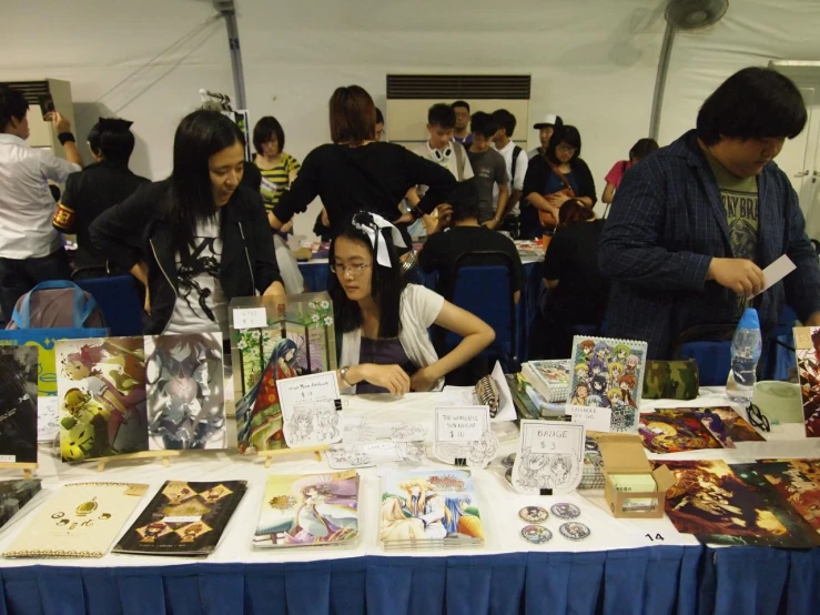 a group of people standing around a table with comics