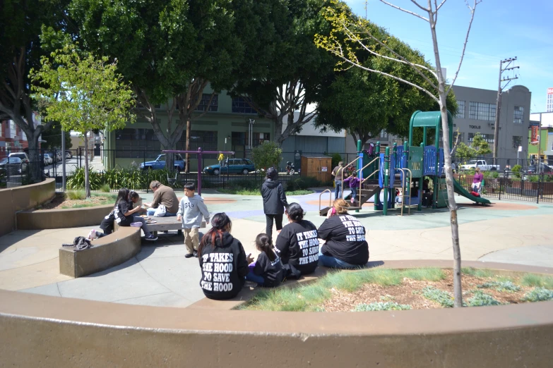 the people are sitting in a circle holding signs