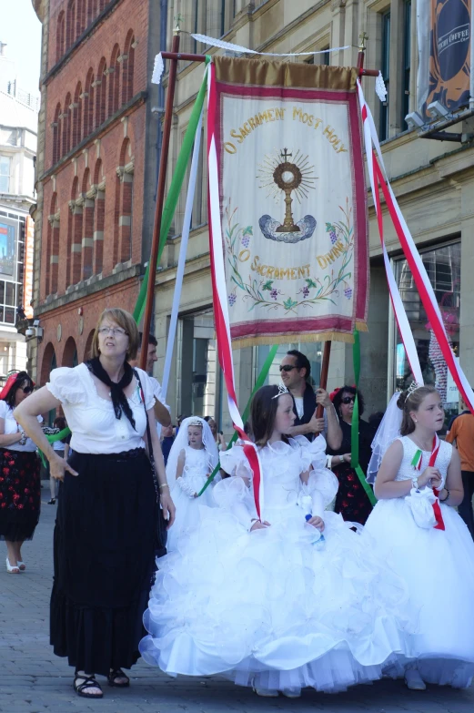 several girls in dresses are standing outside on a sidewalk