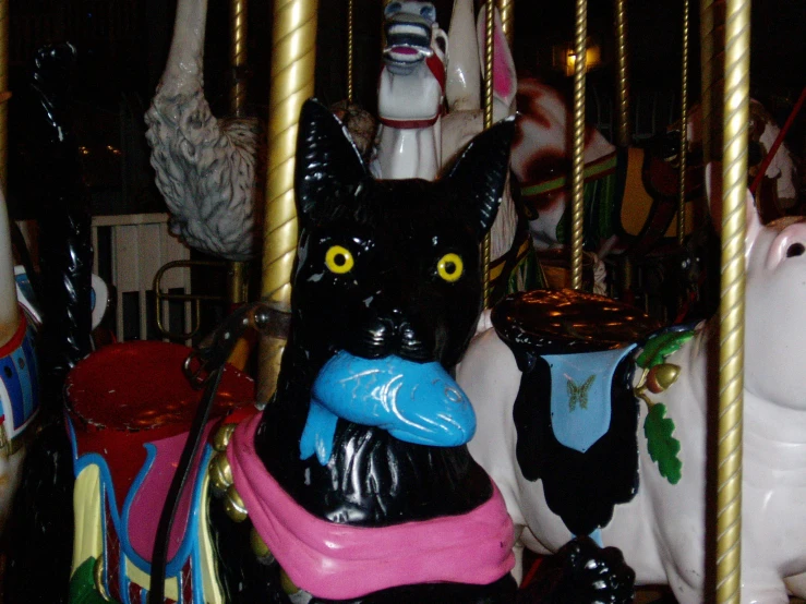 a black cat on top of a merry go round at an amut park