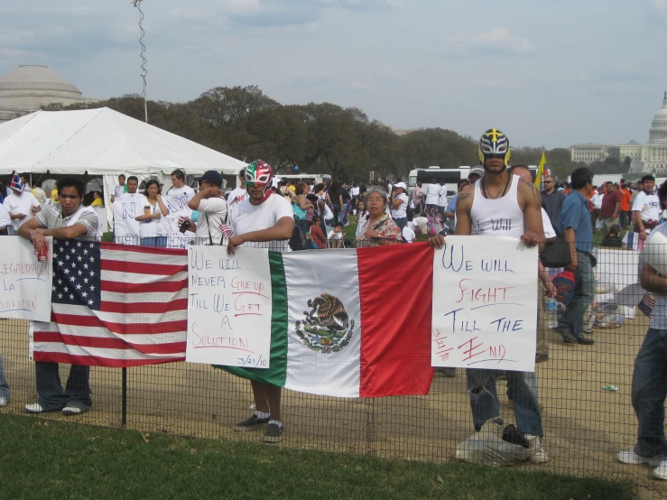 a group of people holding up flags in the dirt