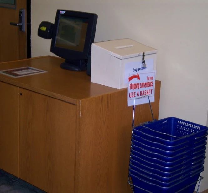 a television and some bins sit on the side of a cabinet