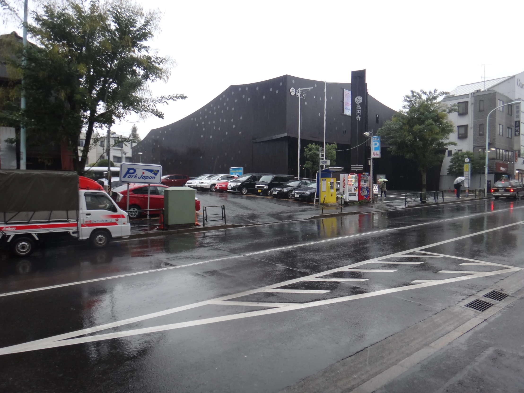 a wet street with many cars parked outside