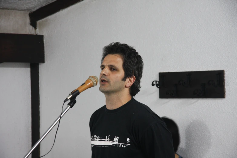 the man is singing into his microphone with a short mic cord in his hand