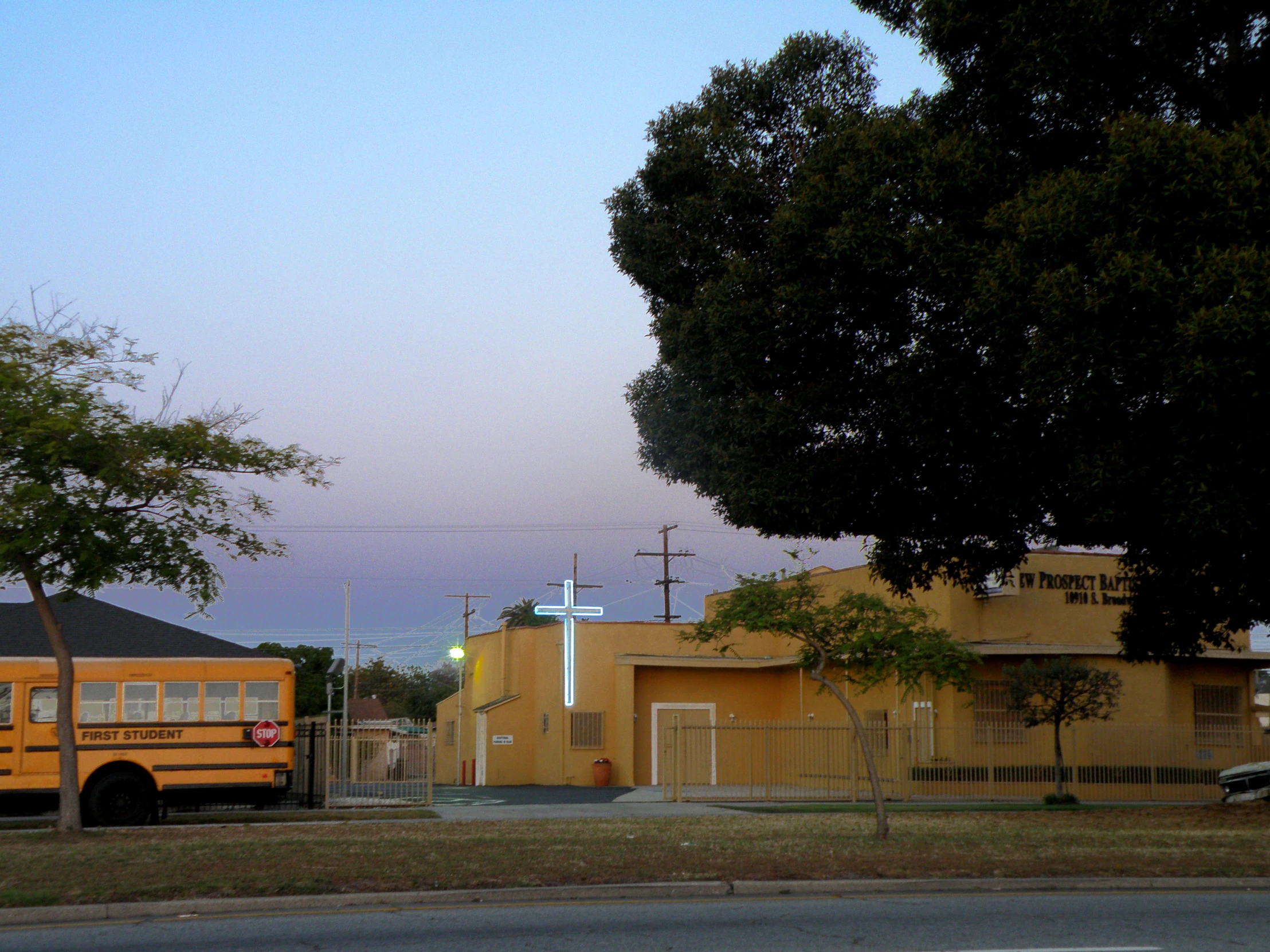 a school bus is parked in front of a small yellow building