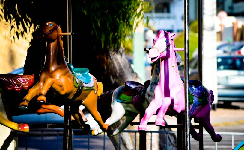 a carousel with several colorful carousel horses and a child's play set