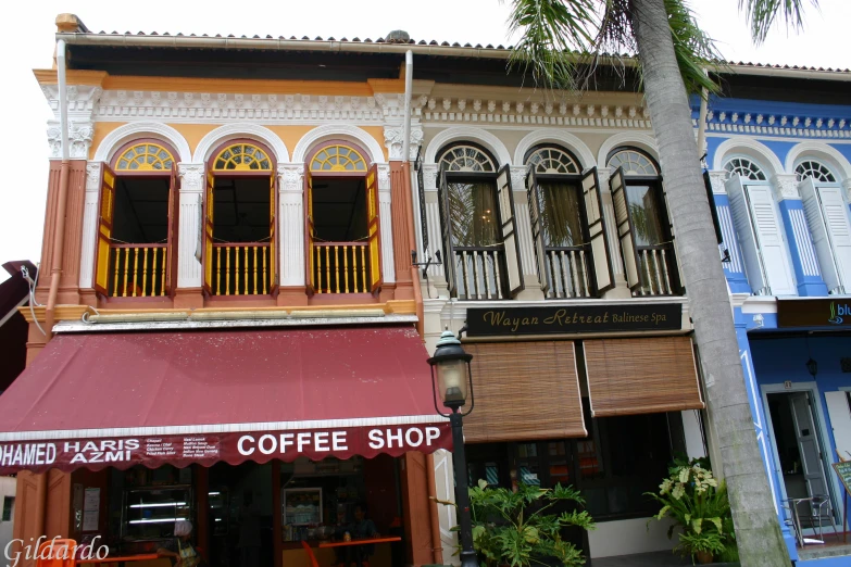 a cafe with three different colored building with awnings