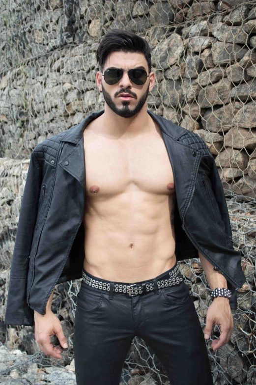 a shirtless man in sunglasses posing for the camera