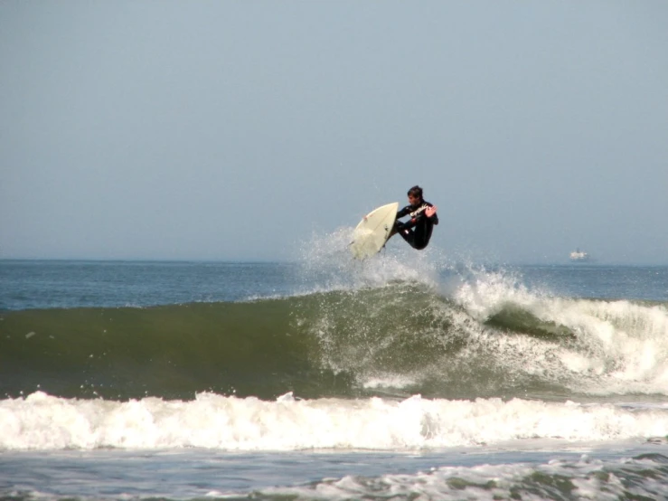 a man riding a wave with a surfboard on his hand