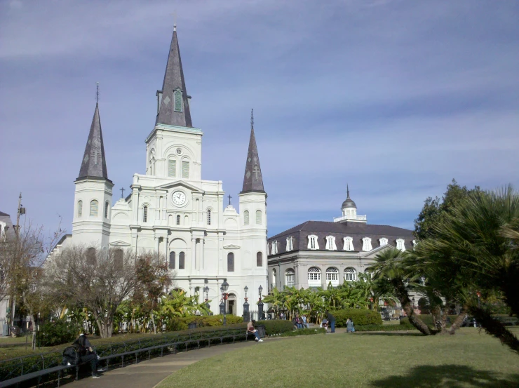 a castle building with steeples on top surrounded by a grassy area