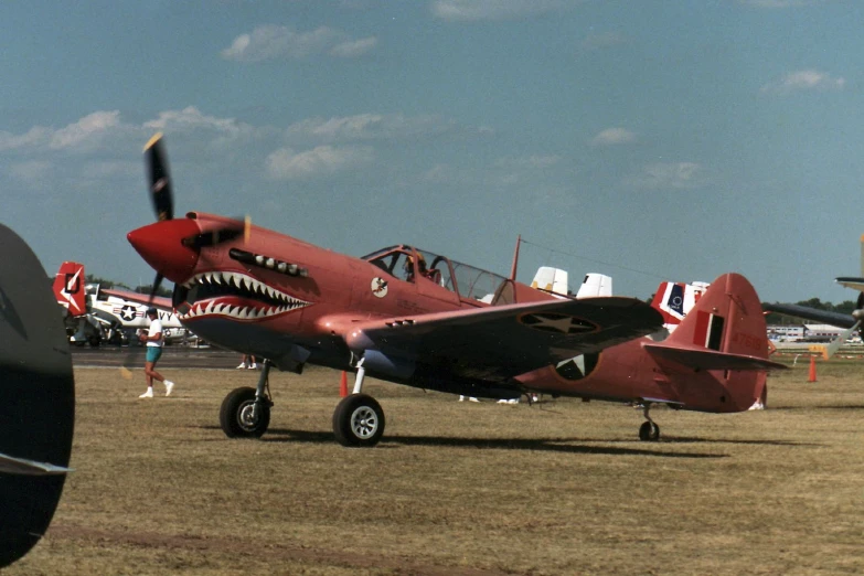 a red and white plane with large jaws on it