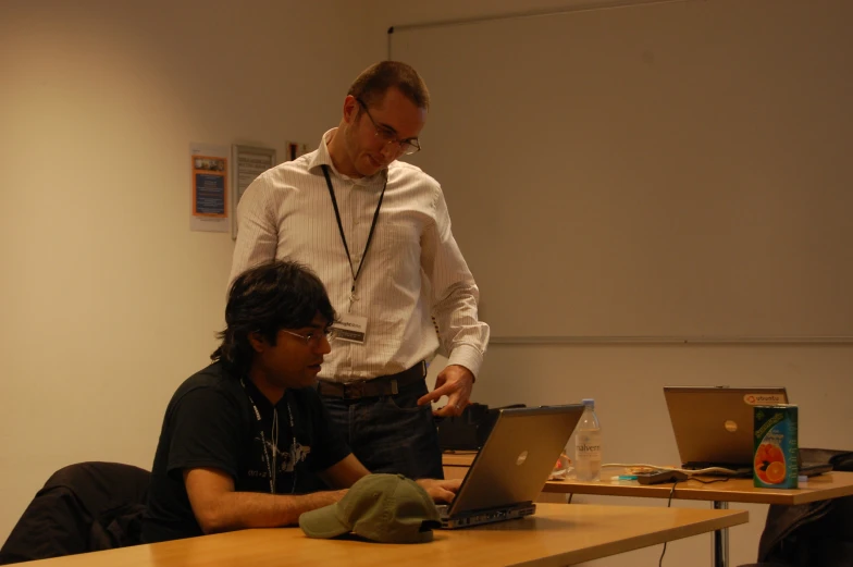 two men working on laptops at a desk