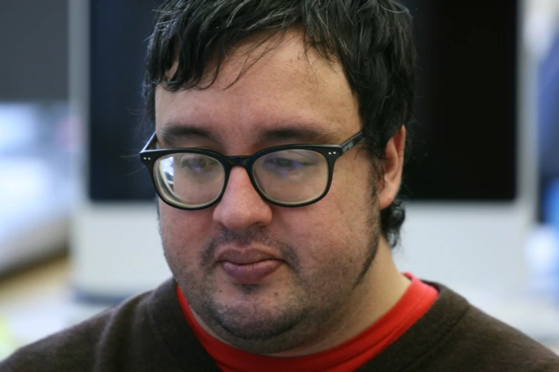 a man is wearing glasses on a work station