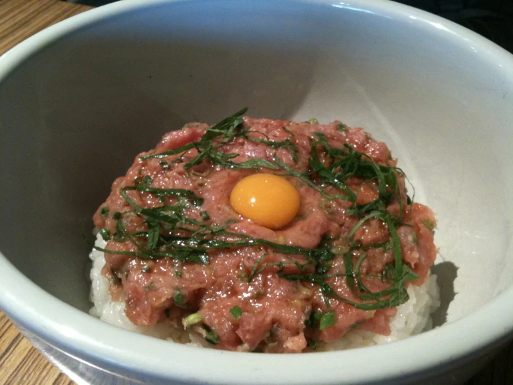 this is an image of a food dish with meat and an egg on top