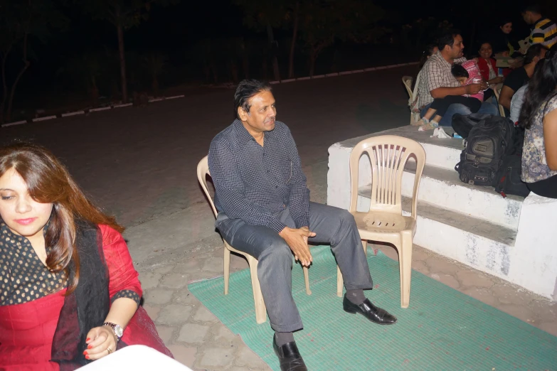 a man sitting in a chair with people around him