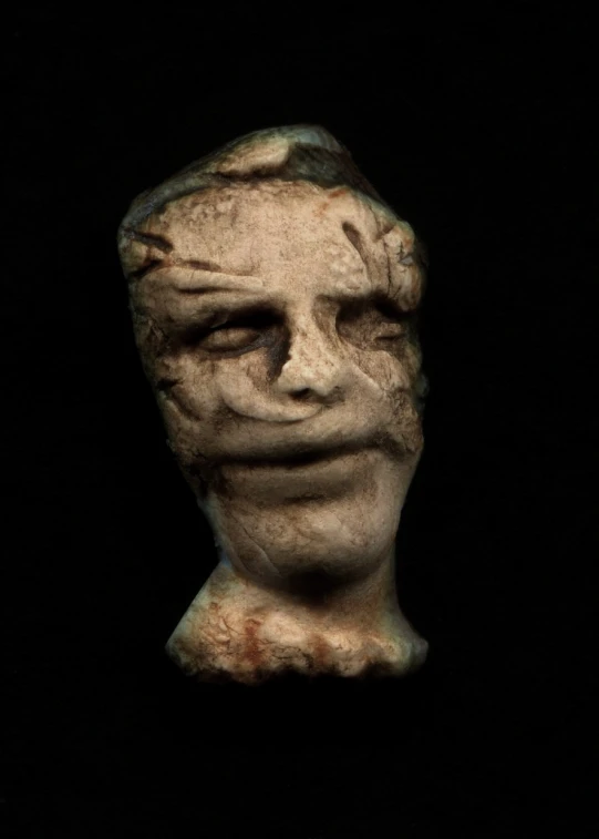 an evil looking head on the back of a dummy