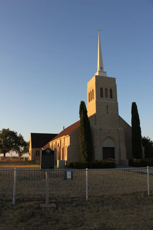 a large church behind a tall fence with a steeple on top