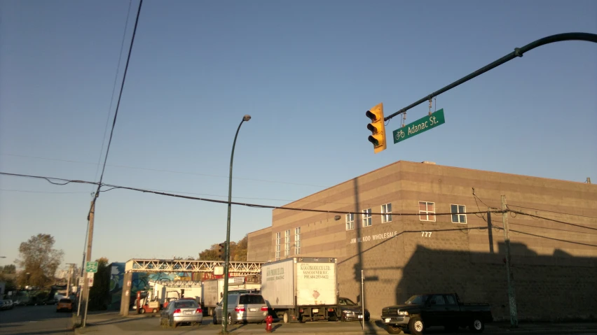 a traffic light on a street with trucks and buildings in the background