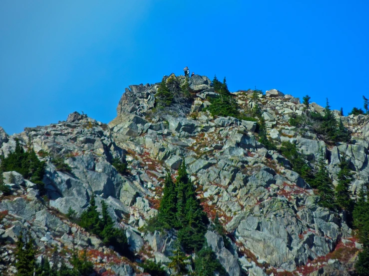 the top of the mountain is rocky and green