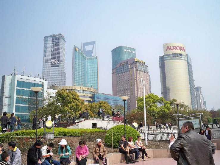 several people sitting on the curb in front of some buildings