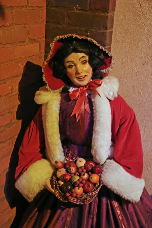 a dolls picture with a dress and hat holding apples