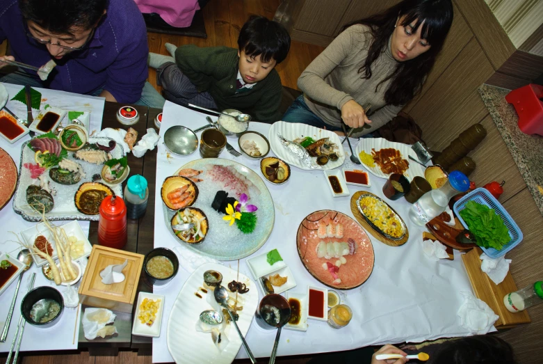 two adults and three children sitting at a table