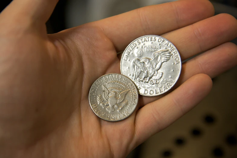 two different types of silver and dimes on someone's hand