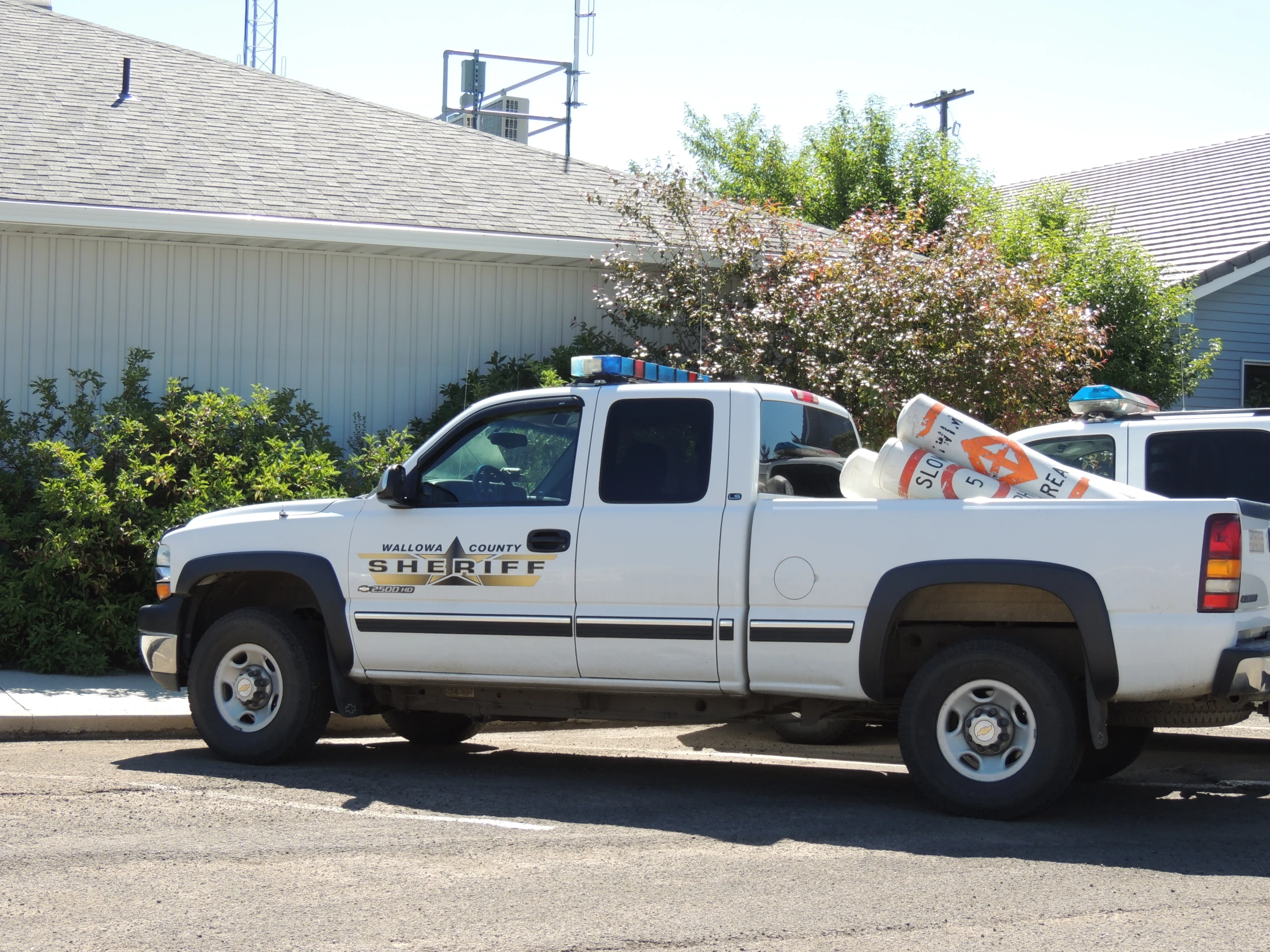 two white truck sitting on the side of a street