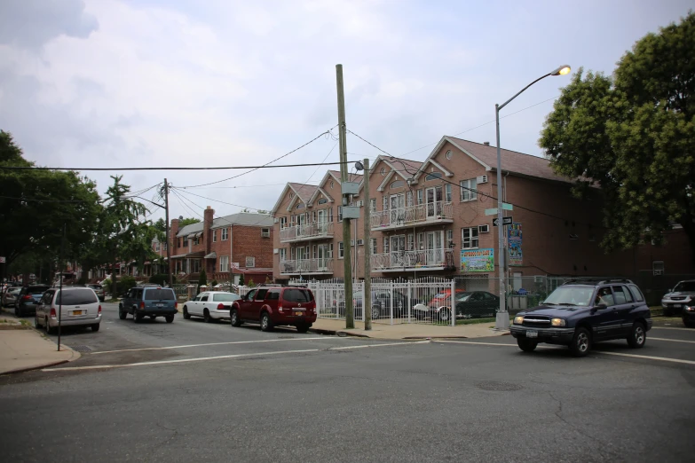 cars on the road outside a large brick building