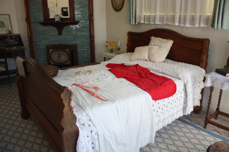 a bedroom with a white comforter and a red blanket