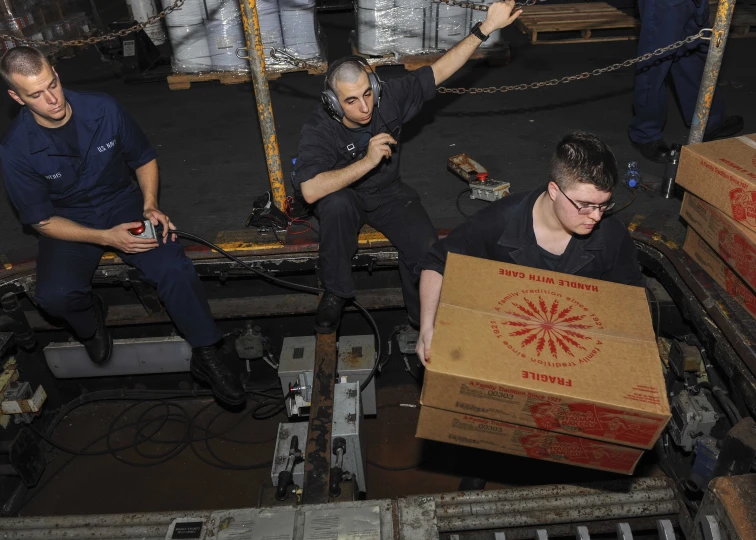 a group of men are sitting around with boxes