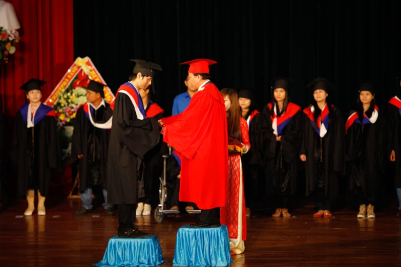 two men standing near each other in graduation gowns