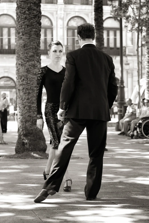 a man in a suit and tie walking next to a woman