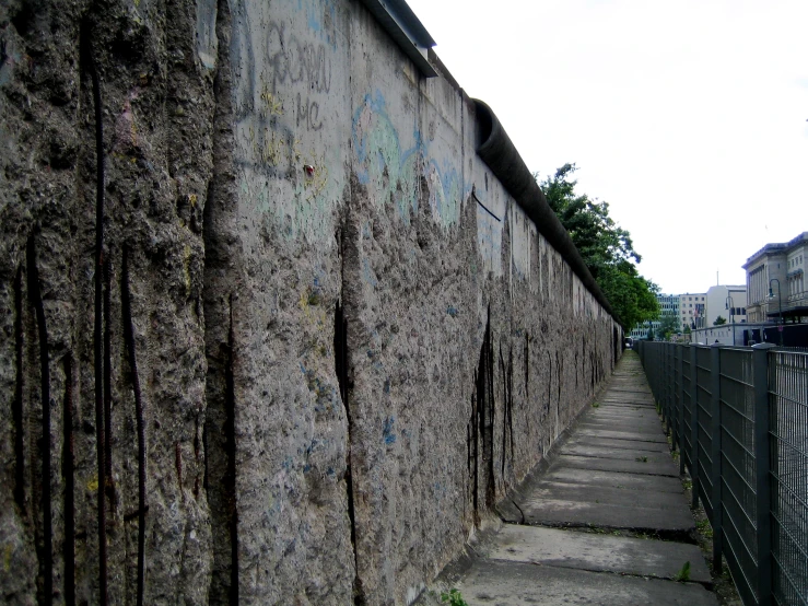 a fence that is by a cement wall