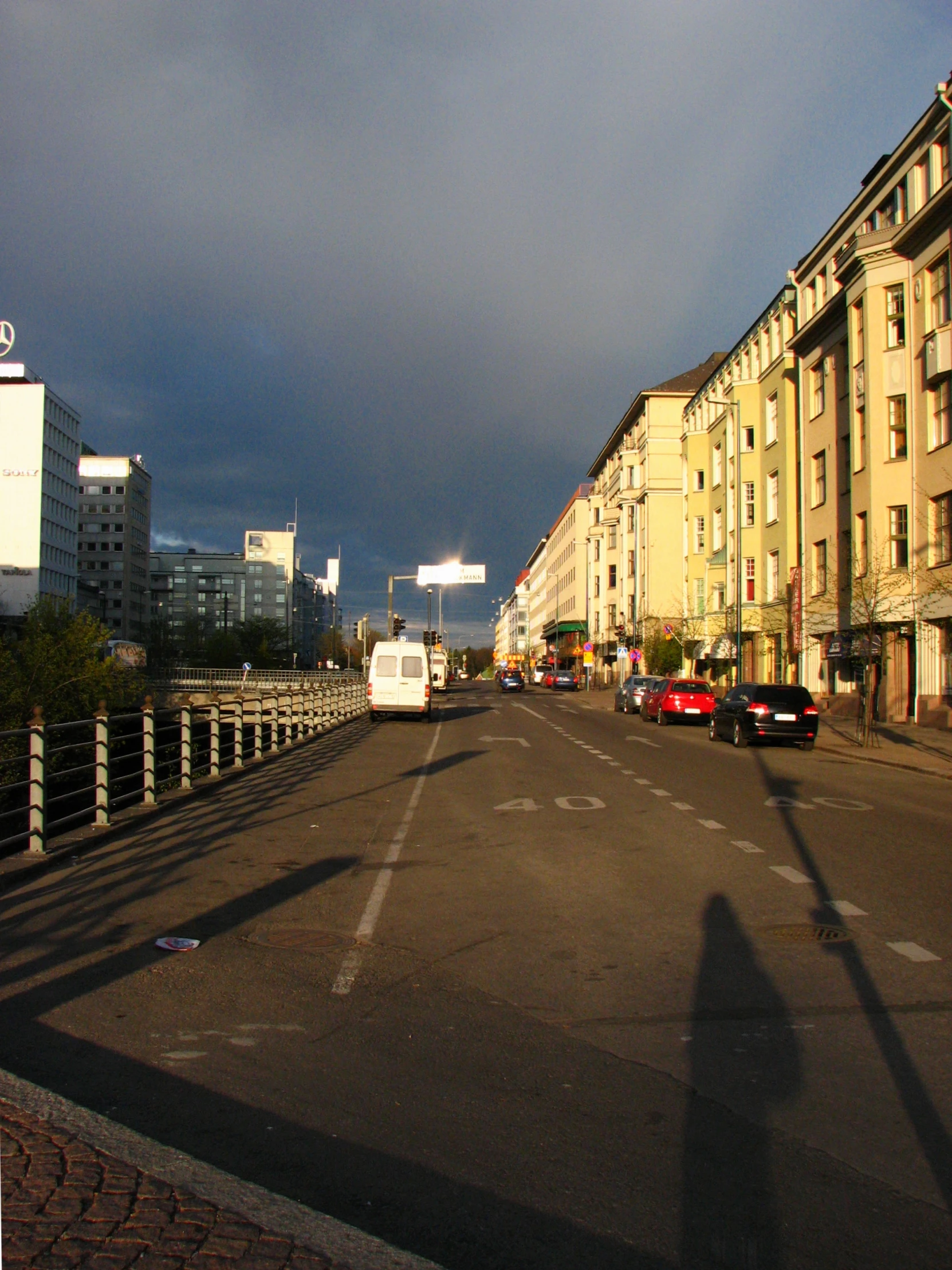 vehicles drive along a wide open city street