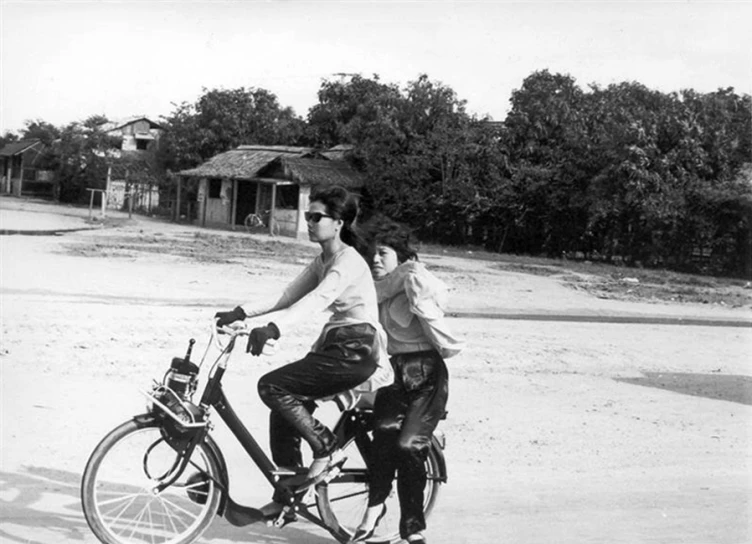 an old po of two people riding a bike