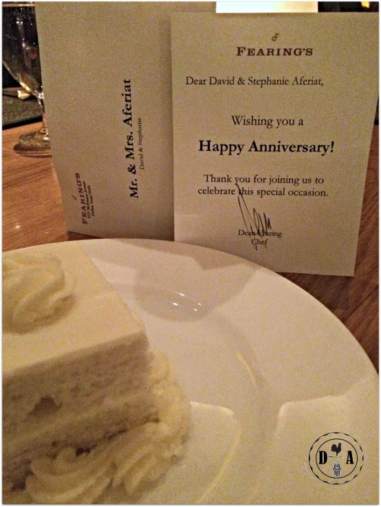 a piece of cake on a plate with an anniversary sign beside it