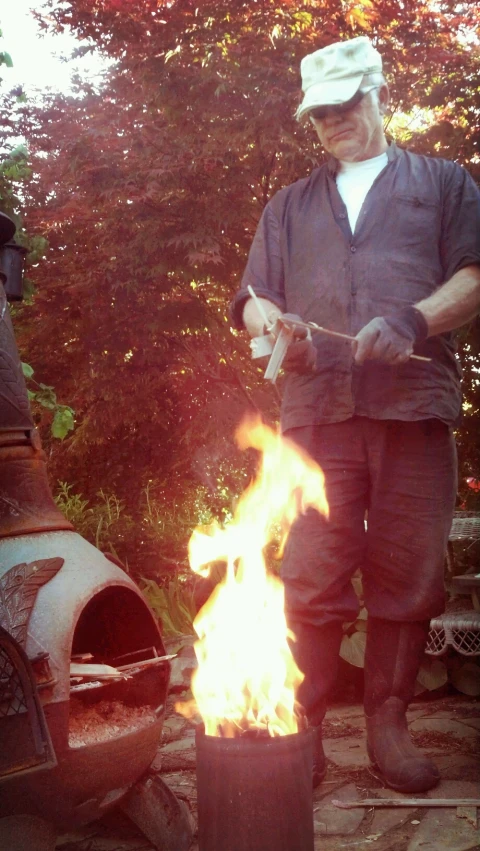 a person cooking soing on a stick over fire