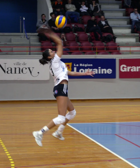 a volleyball player jumps up to hit the ball