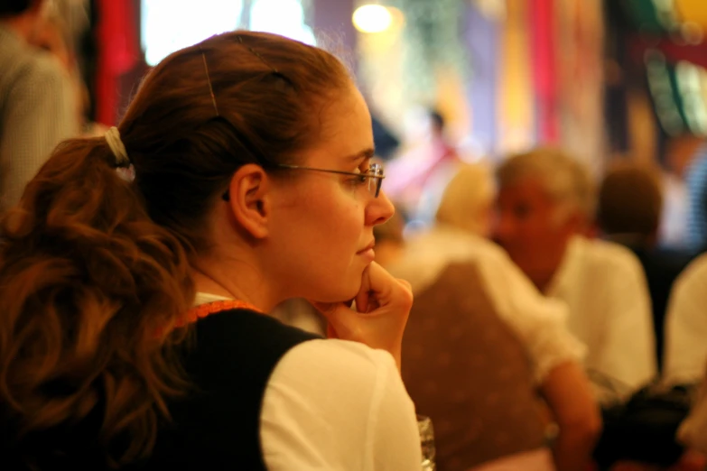 a woman with glasses and a ponytail looking at soing